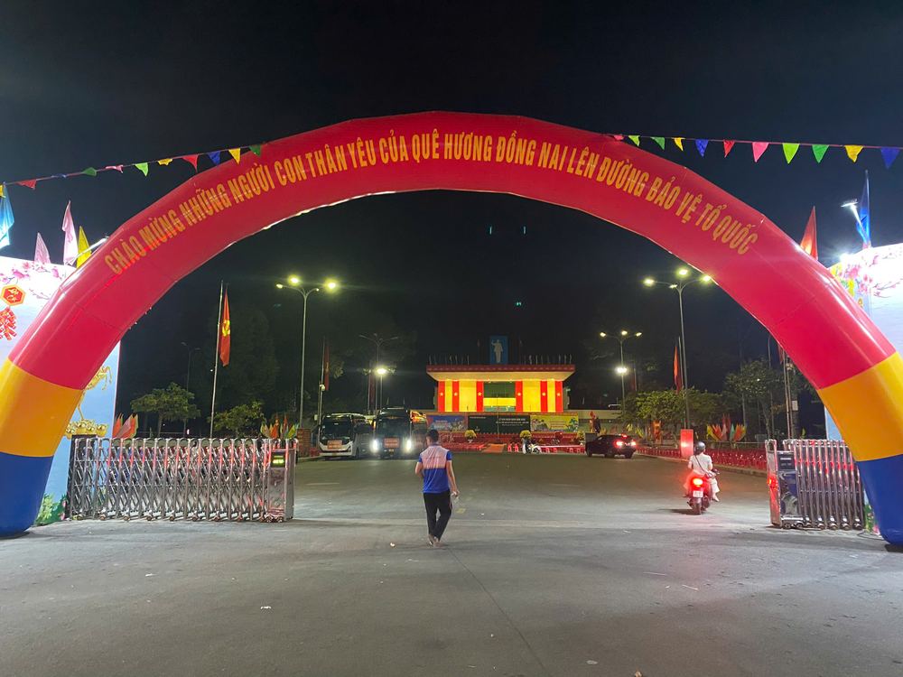 Cổng hơi đỏ in chữ chào mừng dựng ngoài trời buổi tối